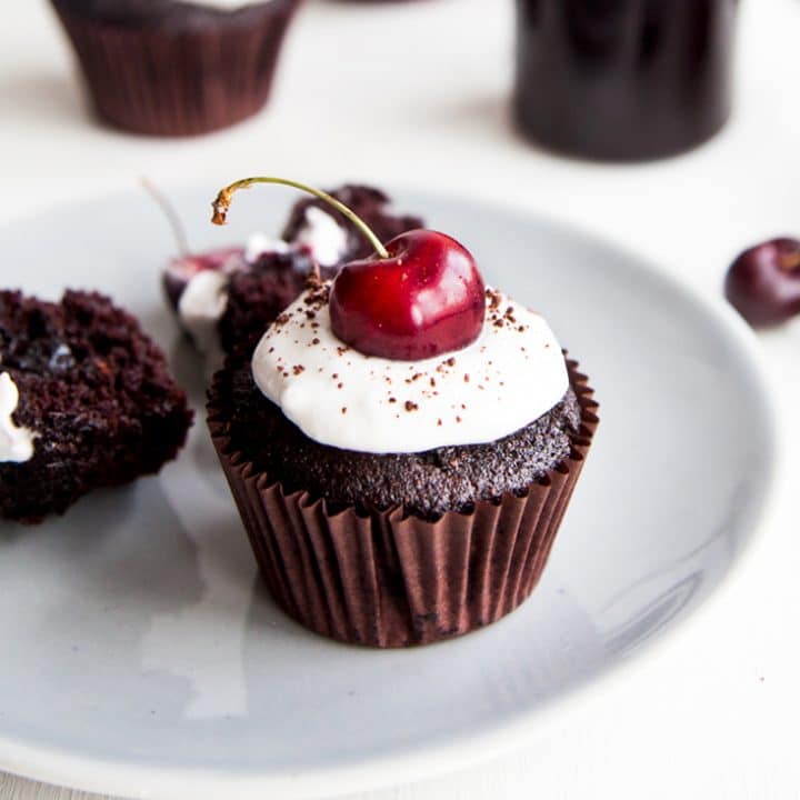 Black Forest Cupcakes! Rich chocolate cupcakes filled with cherry jam and topped with coconut cream (vegan + no refined sugars)