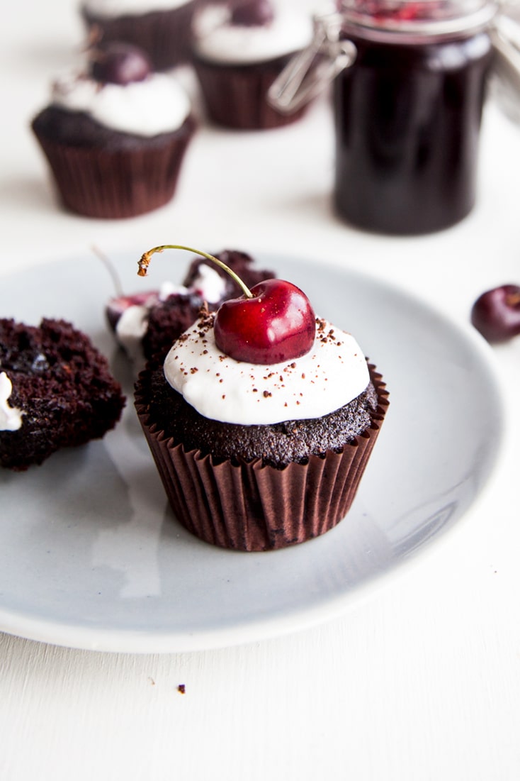 Black Forest Cupcakes! Rich chocolate cupcakes filled with cherry jam and topped with coconut cream (vegan + no refined sugars)
