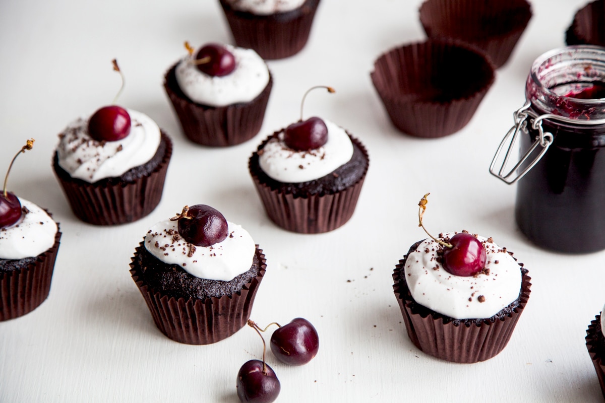 Black Forest Cupcakes! Rich chocolate cupcakes filled with cherry jam and topped with coconut cream (vegan + no refined sugars)