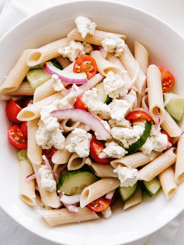 Penne, fresh tomato, cucumbers, red onion and a homemade vegan almond feta make up this fresh and tasty Greek pasta salad. Gluten-free option.