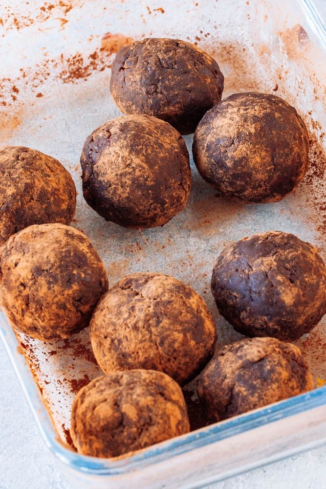 Chocolate energy balls being tossed in cocoa powder