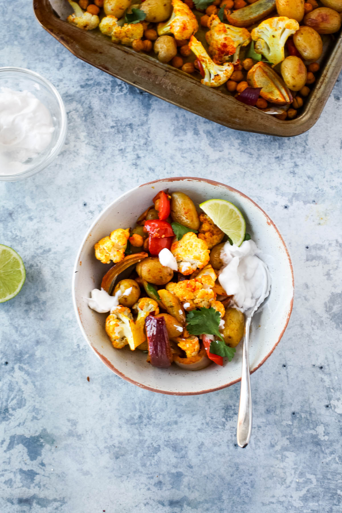 A bowl of Easy Aloo Gobi Traybake with Chickpeas & Coconut Yoghurt (Vegan and Gluten-free) 